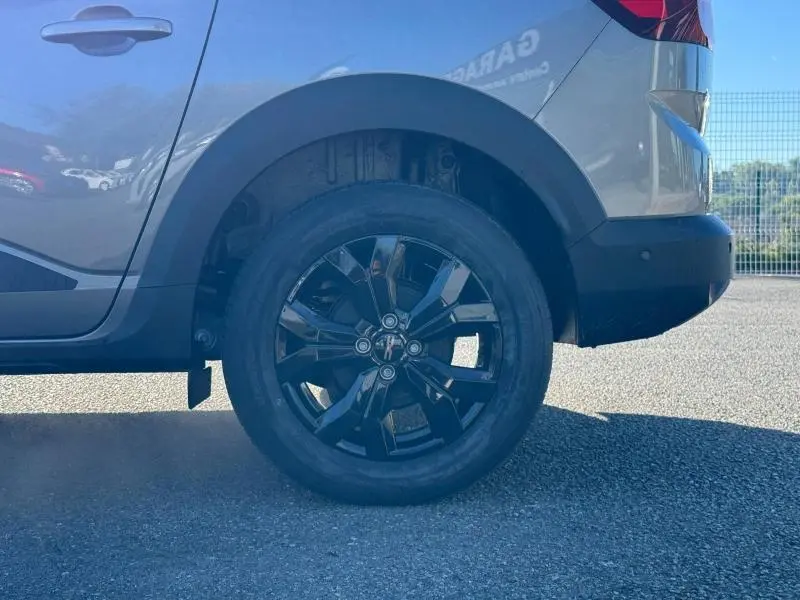 Gros plan sur la roue arrière droite d'un Dacia Jogger gris schiste métallisé avec jante alu noire brillante.