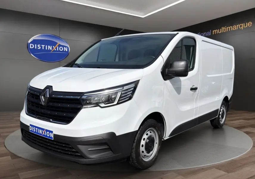 Fourgon Renault Trafic blanc en vue 3/4 avant droit, avec calandre noire et phares LED distinctifs.