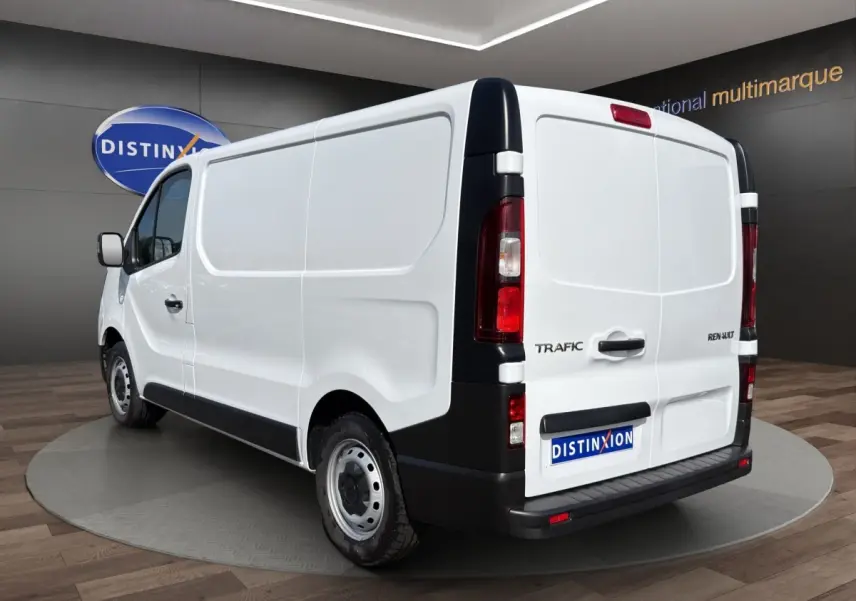 Vue 3/4 arrière droite d’un Renault Trafic Fourgon blanc avec portes arrière pleines et feux verticaux rouges.