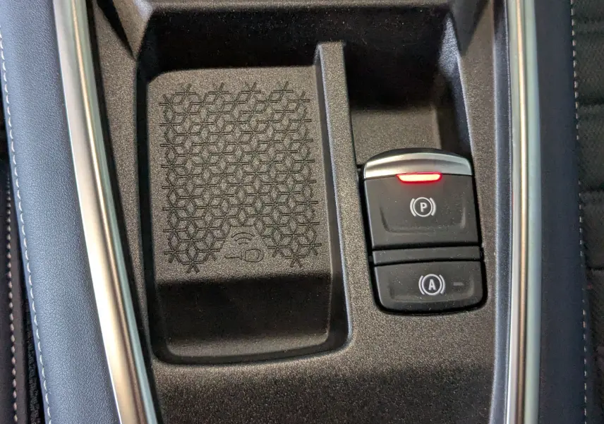 Gros plan sur la console centrale noire de l'Alpine A290 220CH GT PERFORMANCE avec boutons de frein à main et stationnement automatique.