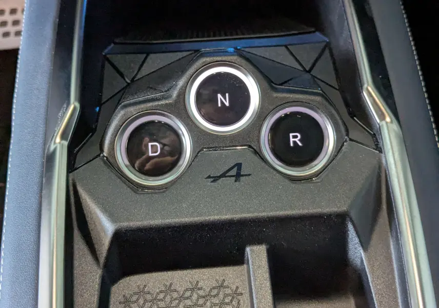 Gros plan sur la console centrale noire de l'Alpine A290 avec boutons de boîte auto D, N, R et logo A.