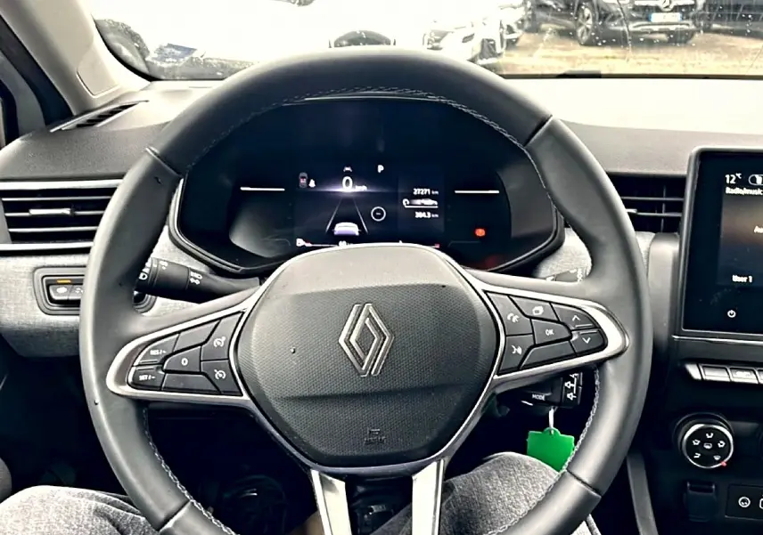 Vue frontale du volant multifonction noir de la Renault Clio V avec tableau de bord numérique et écran tactile central.
