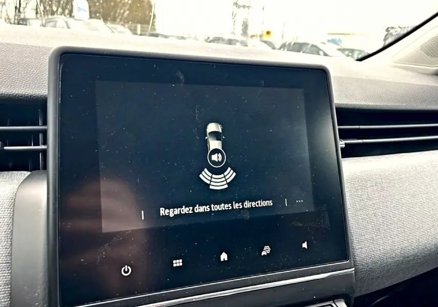 Écran tactile central du tableau de bord de Renault Clio V, affichant une alerte de détection d’obstacles.