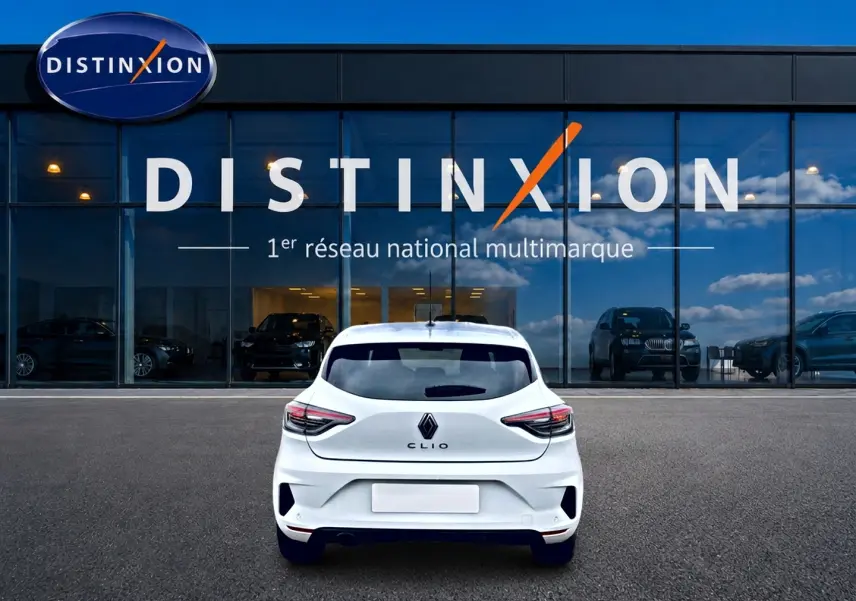 Vue arrière d'une Renault Clio V blanche 2025 garée devant une vitrine avec logo Distinxion.