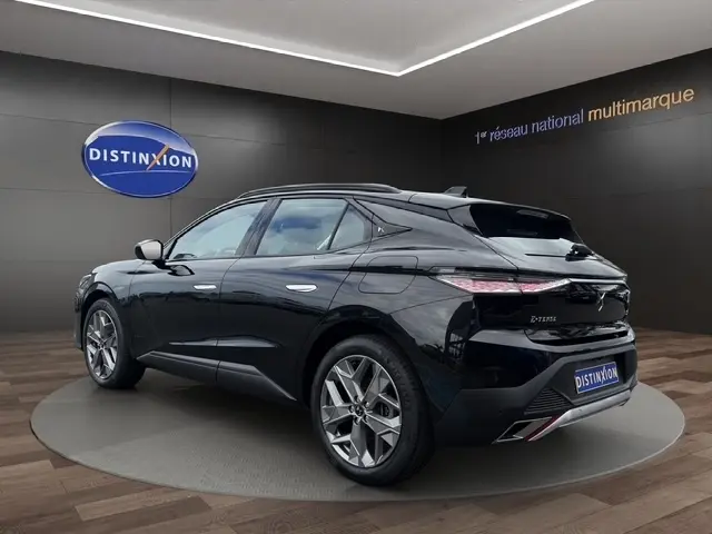Vue 3/4 arrière droite d'une DS4 E-TENSE 225 Cross Trocadero noire, soulignant ses lignes élégantes et ses feux LED distinctifs.