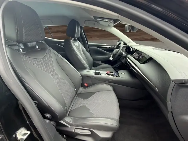 Intérieur noir du DS4 E-TENSE 225 Cross Trocadero, vue côté conducteur, sièges cuir et tableau de bord moderne avec écran tactile.