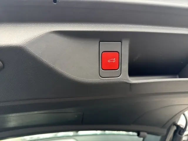 Bouton rouge d'ouverture de coffre sur le hayon intérieur d'une DS4 E-TENSE 225 noir, vue rapprochée.