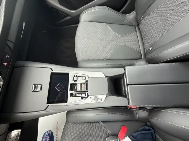Vue plongeante sur la console centrale et sièges avant gris du DS4 E-TENSE 225 Cross Trocadero 2023, intérieur moderne et épuré.
