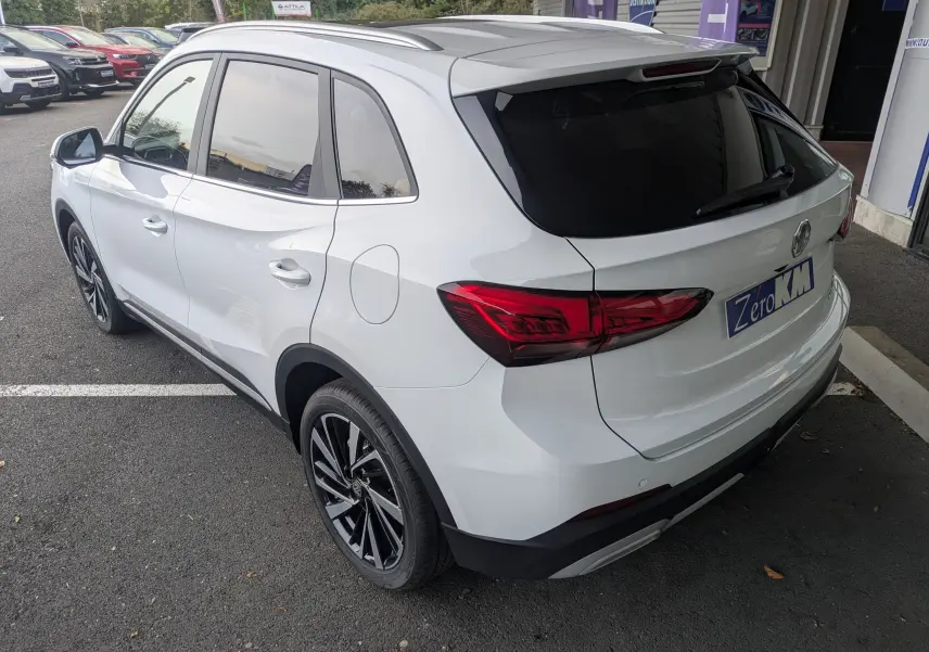 Vue 3/4 arrière droite du SUV MG ZS blanc avec toit panoramique et jantes alliage noires.