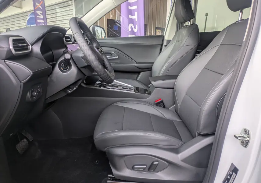 Vue intérieure côté conducteur du MG ZS blanc 2026, sièges en similicuir noir perforé avec réglages électriques et volant cuir.