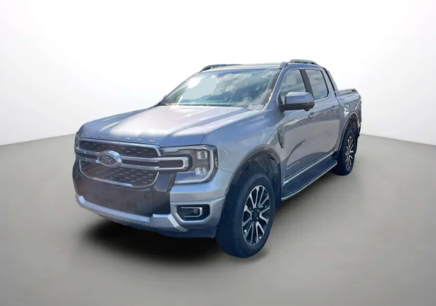 Ford Ranger 3.0 V6 gris iconic en 3/4 avant droit, avec jantes alu 20 pouces et barres de toit visibles.
