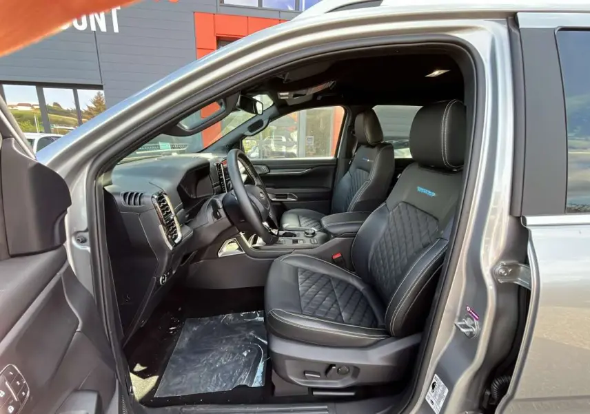 Vue intérieure côté conducteur du Ford Ranger gris iconic 2026, sièges cuir noirs matelassés avec logo Platinum Rideau.