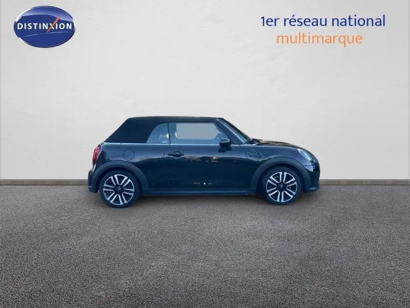 Profil droit d'une MINI Cabriolet Cooper 2023 en Midnight Black II avec capote fermée et jantes alu distinctives.