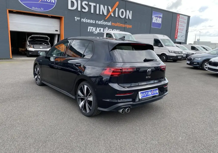 Volkswagen Golf VIII GTD noire vue 3/4 arrière droit, avec jantes alliage 18 pouces et double sortie d’échappement chrome.
