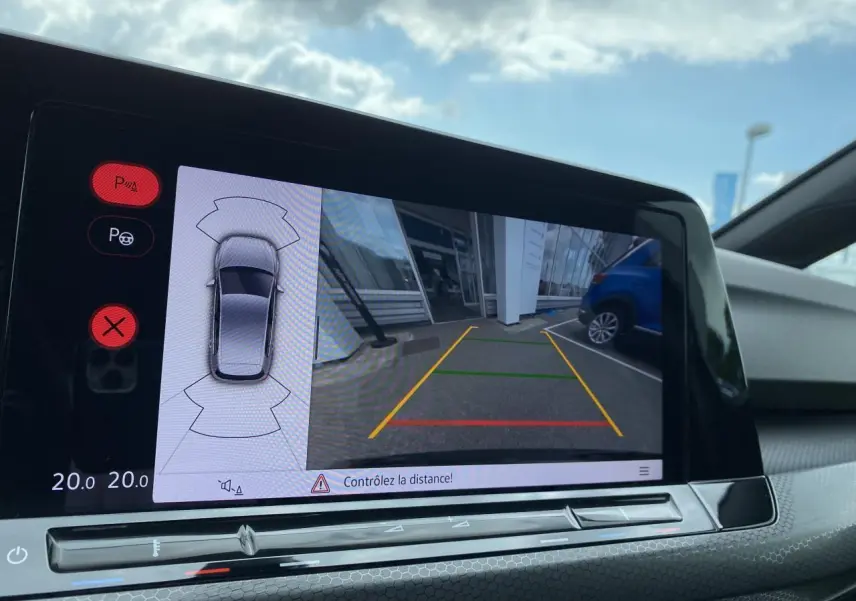 Affichage de la caméra de recul et des capteurs de stationnement sur l'écran tactile intérieur de la Volkswagen Golf noire.