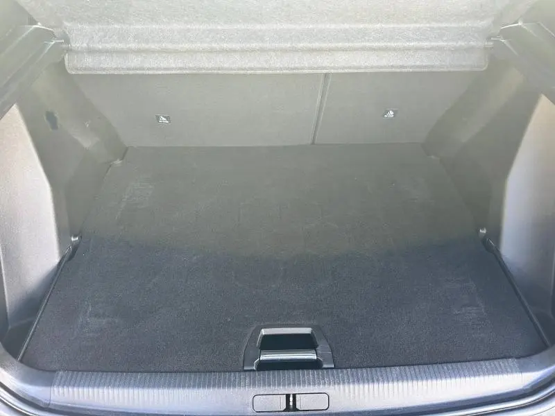 Coffre spacieux ouvert du Peugeot 2008 gris Artense, montrant le plancher de coffre et les fixations Isofix arrière.