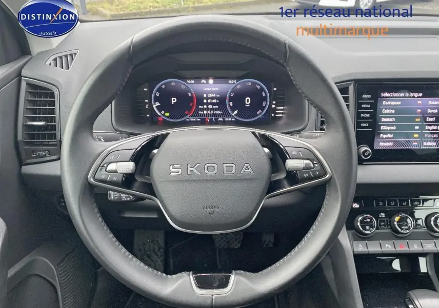 Vue intérieure frontale du volant cuir noir SKODA KAROQ 2025 avec tableau de bord numérique et écran tactile multimédia.