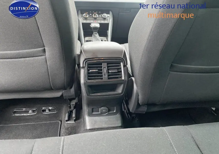 Vue intérieure arrière du Skoda Karoq noir 2025, montrant la console centrale avec bouches d'aération et prise 12V.