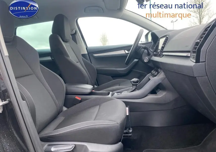 Vue intérieure côté gauche du Skoda Karoq noir 2025, mettant en valeur les sièges avant et la console centrale.