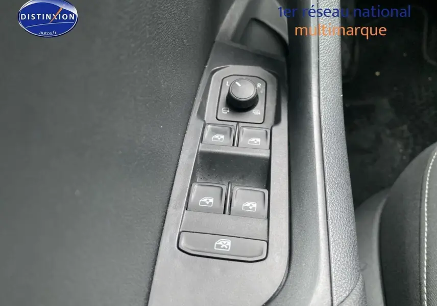 Gros plan sur les commandes des vitres et rétroviseurs côté conducteur d’un Skoda Karoq noir 2025.