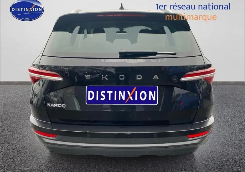 Vue arrière d'un Skoda Karoq noir 2025 avec feux arrière LED et logo distinctif sur fond neutre.