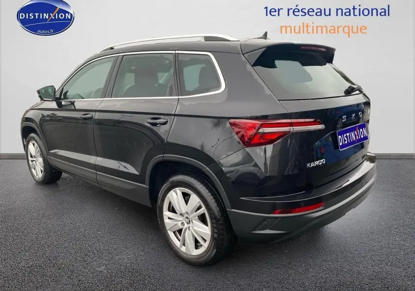 Vue 3/4 arrière droite d'un Skoda Karoq noir avec jantes alu et feux arrière LED distinctifs.