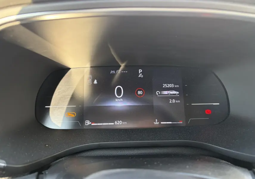 Tableau de bord numérique du Renault Arkana 2025, affichage vitesse, autonomie et alertes, vue de face rapprochée.