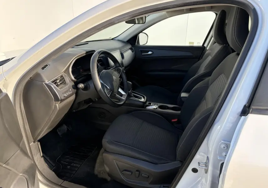 Vue intérieure côté conducteur d'un Renault Arkana blanc glacier 2025 avec sièges noirs et tableau de bord moderne.