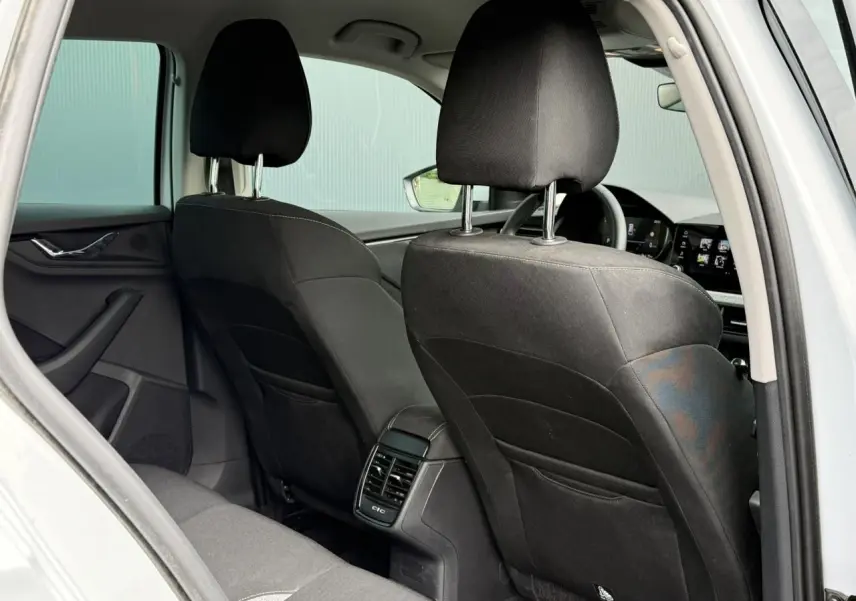 Vue arrière intérieure de la Skoda Scala blanc glacier, montrant les sièges noirs et la console centrale avec aérateurs.