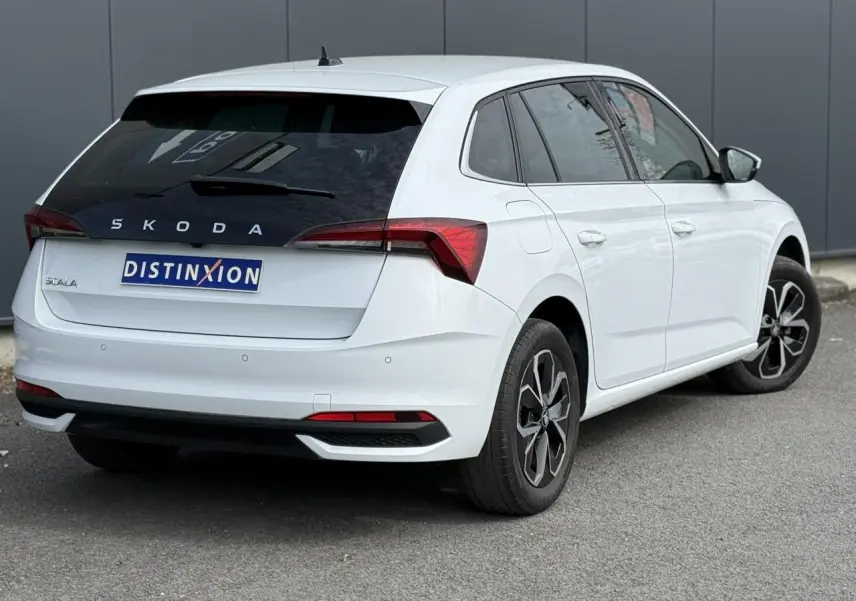 Vue 3/4 arrière droite d'une Skoda Scala blanc glacier avec vitres surteintées et jantes alliage 16 pouces.