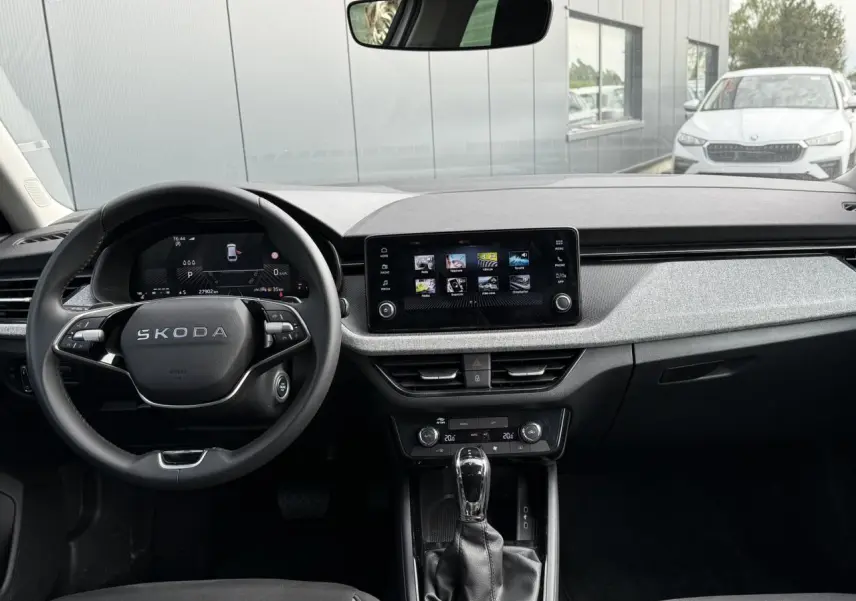 Vue intérieure frontale du tableau de bord de la Skoda Scala blanc Glacier, avec écran tactile et volant multifonction.