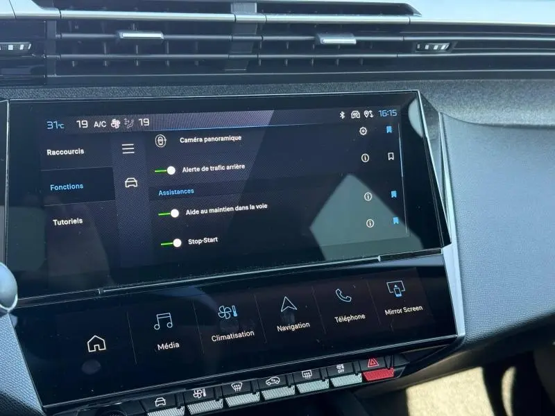 Écran tactile central du tableau de bord de la Peugeot 308 gris, affichant les options d'assistance à la conduite.