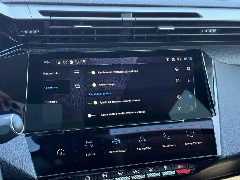 Vue rapprochée de l’écran tactile central du Peugeot 308 gris 2025, affichant les réglages d’aides à la conduite.