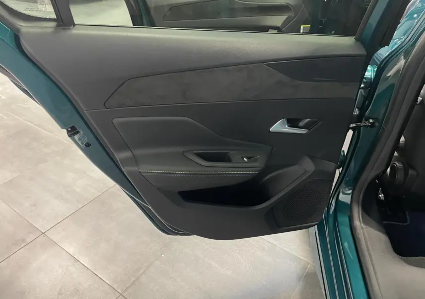 Vue intérieure de la porte arrière gauche bleu métallisé de la Peugeot 308 GT avec surpiqûres vert Adamite.