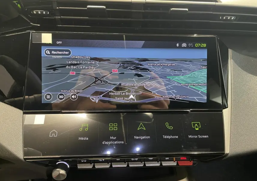 Vue rapprochée de la console centrale noire avec écran tactile affichant la navigation sur Peugeot 308 bleu.