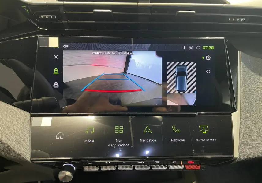 Écran tactile central affichant la caméra de recul et les options multimédia dans une Peugeot 308 GT bleue.