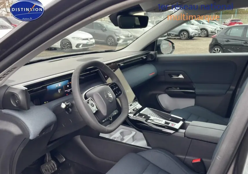 Vue intérieure côté conducteur du Citroën C5 Aircross hybride 2026, avec tableau de bord moderne et sièges gris foncé.