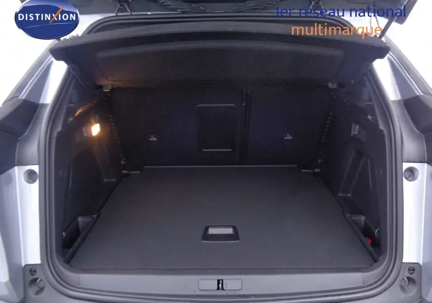 Coffre ouvert d'un Peugeot 3008 gris Artense métal, vue arrière montrant un espace de chargement spacieux et bien éclairé.