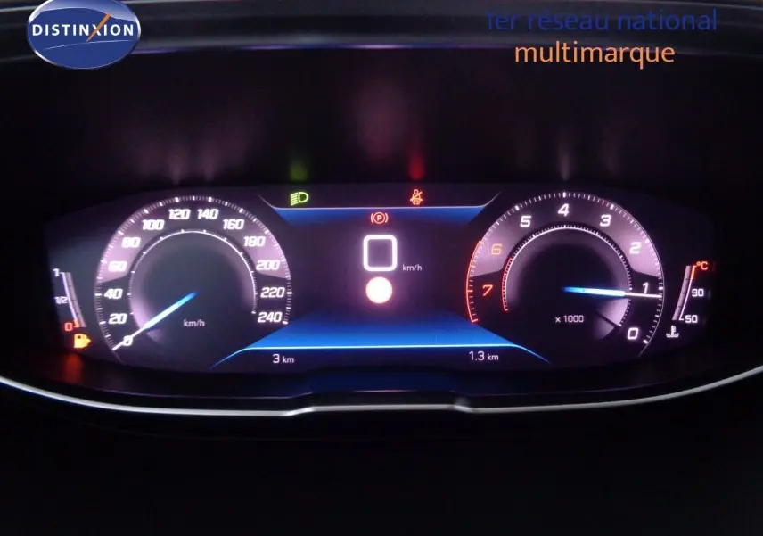 Tableau de bord numérique du Peugeot 3008 2023 affichant vitesse, compte-tours et indicateurs lumineux en intérieur sombre.
