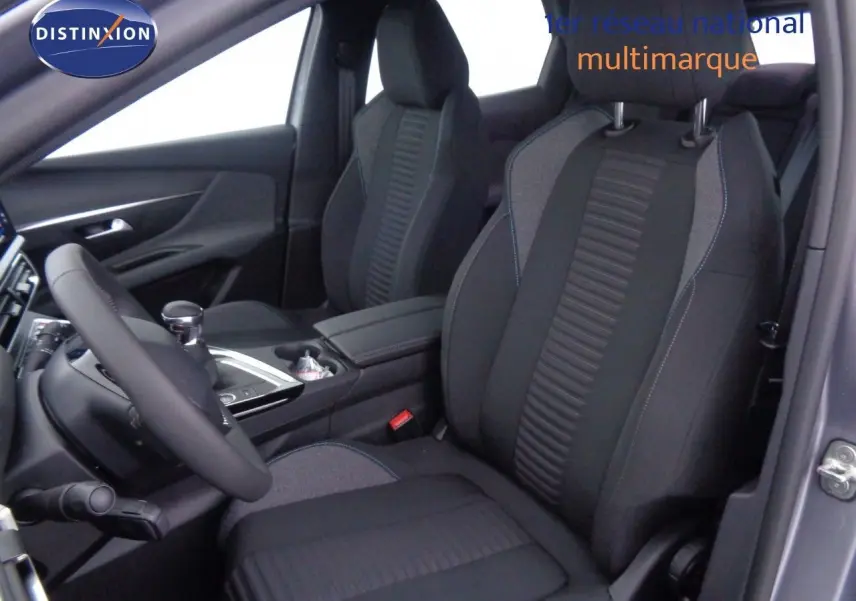 Vue intérieure côté conducteur du Peugeot 3008 2023 gris Artense Metal, sièges tissu gris et noir avec surpiqûres bleues.