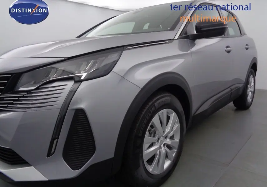 Gros plan sur la roue avant gauche d'un Peugeot 3008 gris Artense métal, avec jante alliage et pneu Michelin.