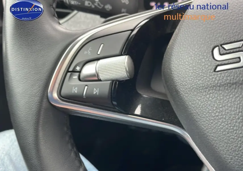 Gros plan sur les commandes gauche du volant cuir noir du Skoda Kamiq gris 2025, avec molette et boutons multifonctions.