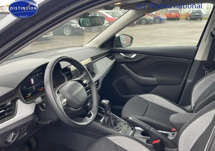 Vue intérieure côté conducteur du Skoda Kamiq gris 2025, volant cuir multifonction et tableau de bord digital.