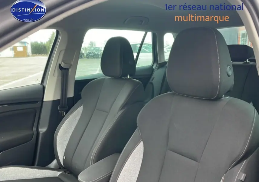 Vue intérieure des sièges avant gris clair et foncé du Skoda Kamiq 2025, avec accoudoir central et ceinture côté gauche visible.