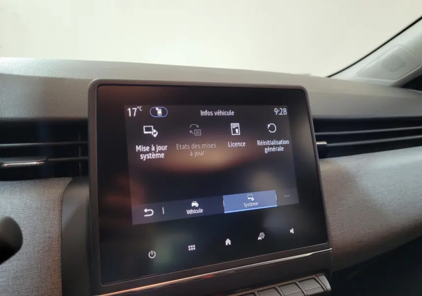 Écran tactile central affichant le menu système du tableau de bord d’une Renault Clio gris foncé, vue intérieure frontale.