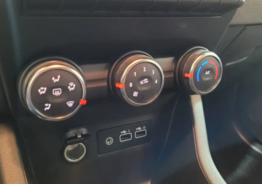 Gros plan sur les commandes de climatisation et les ports USB de la Renault Clio gris foncé Evolution Blue dCi 100, intérieur avant.