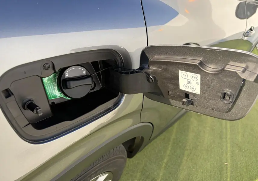 Gros plan sur la trappe de carburant ouverte côté gauche d’un Renault Arkana gris métallisé 2025.