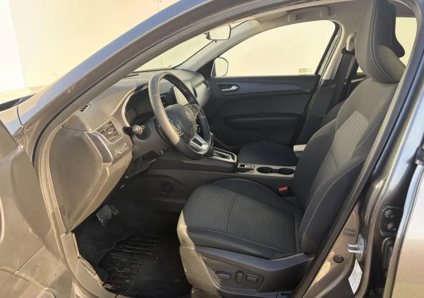 Vue intérieure côté conducteur du Renault Arkana gris métallisé 2025, siège électrique avec réglage lombaire et volant textile.