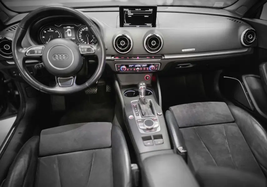 Intérieur de l'Audi A3 Cabriolet 2015 vu de face, sièges alcantara/cuir noirs et console centrale avec boîte auto.