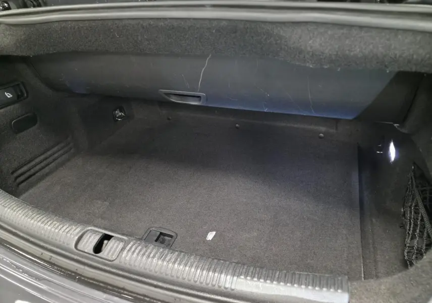 Coffre ouvert de l'Audi A3 Cabriolet gris, montrant l'espace de rangement intérieur avec éclairage latéral.